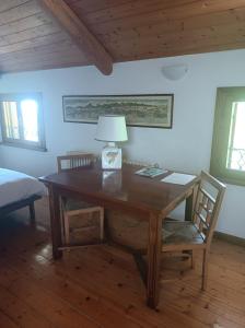 a desk with a lamp and a chair in a room at Fondazione Lucia De Conz in San Gregorio nelle Alpi,