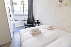 a white bed with two towels on top of it at Contemporary Chic with Terrace & Balcony in Madrid +11 photos