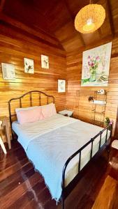 a bed in a room with a wooden wall at Rang Robin Farmstay for 4 with pool in Ban Wang Muang