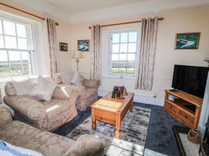 a living room with two couches and a television at Old Higher Lighthouse Stopes Cottage in Southwell