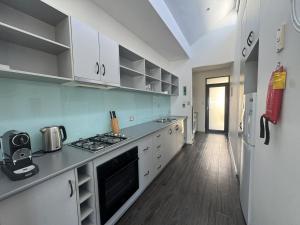 a kitchen with white cabinets and a refrigerator at Esperance Waterfront Apartment in Esperance