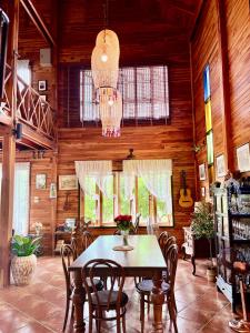 a dining room with a table and chairs and a chandelier at Rang Robin Farmstay for 4 with pool in Ban Wang Muang