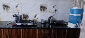 a kitchen counter with a coffee maker on a stove at Alavyahomestay in Kilba