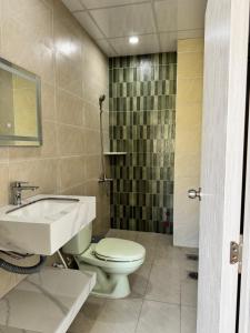 a bathroom with a toilet and a sink at Nhà nghỉ Thu Hoạch in Hà Tiên