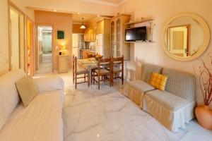 a living room with two couches and a dining room at Seafront Apartment with Panoramic Rooftop Terrace in Paramonas
