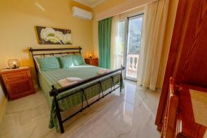 a bedroom with a bed and a large window at Seafront Apartment with Panoramic Rooftop Terrace in Paramonas