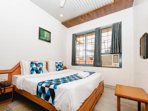 a bedroom with a bed and a window at HOTEL GALAXY SURAT in Surat