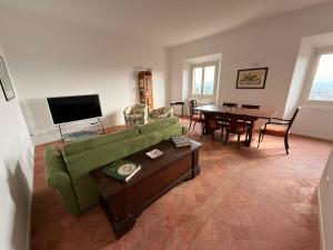 a living room with a green couch and a table at Suite Agli Spaldi in Iesi