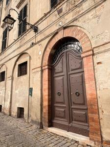 a large brown door on the side of a building at Suite Agli Spaldi in Iesi