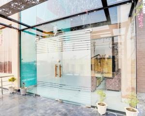 a glass door of a building with potted plants at Hotel Aroma Regency in Meerut