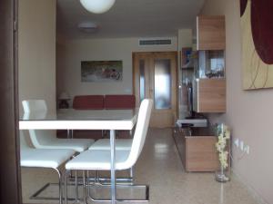 a living room with a table and white chairs at Mirant el Mar in Port Saplaya