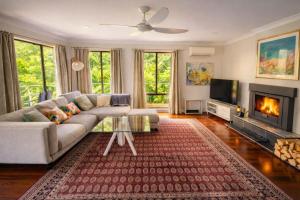 a living room with a couch and a fireplace at Blue Mountains charm with Spa! in Wentworth Falls