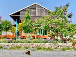 a dog laying on the ground in front of a house at Rang Robin Farmstay with swimming pool in Ban Wang Muang