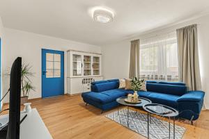 a living room with a blue couch and a table at Vila Ochutnej Pálavu in Pavlov