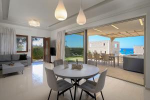 a dining room and living room with a table and chairs at Diamond Dream 4 in Kalamaki