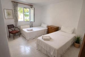 a room with two beds and a chair and a window at Auba Mar - Alcudia Sea View in Alcudia