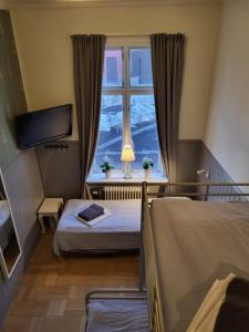 a bedroom with two beds and a window at Vandrarhem Uppsala Kungsängstorg in Uppsala