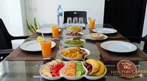 a table topped with bowls of food and orange juice at Horton Grand Boralanda in Haputale