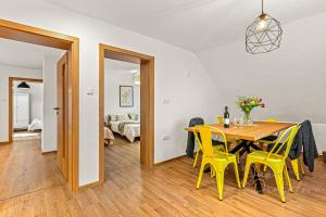 a dining room with a table and yellow chairs at Vila Ochutnej Pálavu in Pavlov
