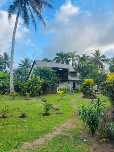 a house with a palm tree in front of a yard at Mirz accomodation FJ in Pacific Harbour