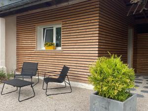 two chairs and a table in front of a house at Chez Fab in Ferrières-lès-Ray