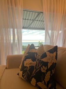 a pillow sitting on a couch in front of a window at Salt & Still in Freeland Park