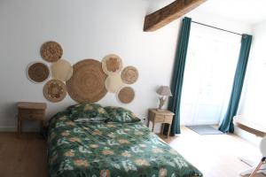 a bedroom with a bed and a wall with plates on it at Chambre Au clos des auges in Saint-Saturnin-du-Bois