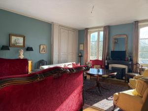 a living room with a red couch and a table at L Epernon in Alençon