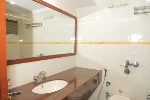 a bathroom with a sink and a mirror at HOTEL GALAXY SURAT in Surat