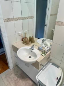 a white bathroom with a sink and a mirror at Botanical Gardens City Cottage in Geelong +16 photos