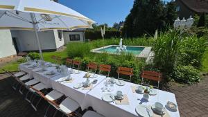 a table with plates and silverware on it next to a pool at Hotel Morgensonne in Augustusburg