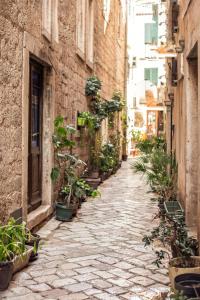 an alley with potted plants on the side of a building at Step to Kotor Bay Old Town in Kotor +31 photos
