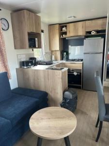 a living room with a couch and a table and a kitchen at domaine de litteau in Litteau