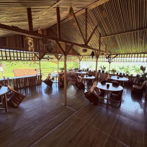a group of people sitting at tables in a pavilion at Rumsram Homestay by Rumah Etnik Papua Sorong in Papermaranda