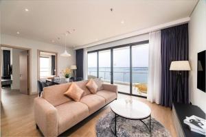a living room with a couch and a view of the ocean at Terra Bay Homestay in Ha Long