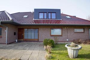 a brick house with a red roof at England 5 in Nordstrand
