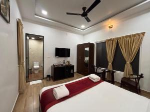 a bedroom with a bed and a flat screen tv at Èden Ember Castle in Gokarna