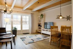 a living room with a table and a tv at Hus Utspann in Nordstrand
