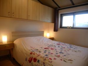 a bedroom with a bed with flowers on it at Zeepolder I 129 in De Haan