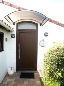 a front door of a house with a brown door at Zeepolder I 129 in De Haan