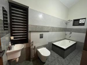 a bathroom with a toilet and a tub and a sink at Chaithanya Residency Near to IIM & NIT Kozhikode in Kunnamangalam +96 photos