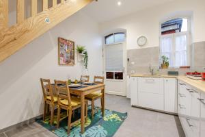 a kitchen with a wooden table and chairs in a kitchen at Duplex City Hag in Haguenau
