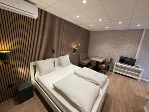 a bedroom with a bed and a desk and a television at hotel de kaaipoort in Aardenburg