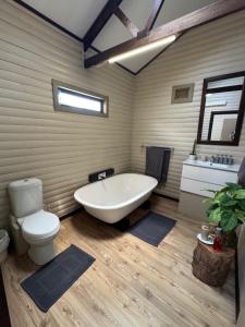 ein Badezimmer mit Badewanne, Toilette und Waschbecken in der Unterkunft Timmerstuga in Malelane + 12 Fotos