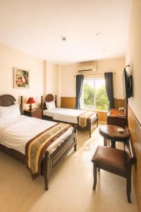 a hotel room with two beds and a window at Hoàng Lê Hotel in Ho Chi Minh City