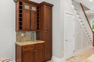a kitchen with wooden cabinets and a staircase at Palm Royale Windsor Townhomes in Key West