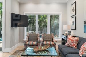 a living room with two couches and a tv at Palm Royale Windsor Townhomes in Key West +30 photos