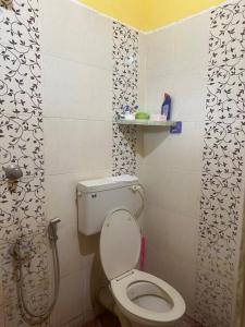 a small bathroom with a toilet and a shower at Hostel Honsa in Cochin