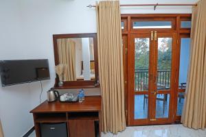 a room with a mirror and a door with a television at Zephyra Ella in Ella