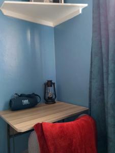a wooden shelf with a lantern on a blue wall at SQ Acacia in Langata Rongai +2 photos